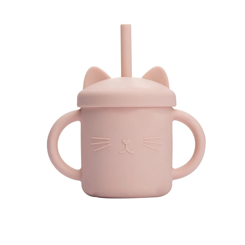 Pink sippy cup with cat ears and face design on a white background