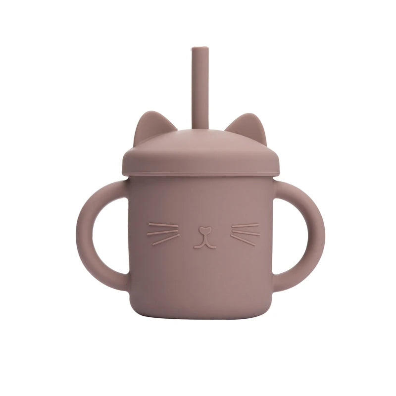 Pink sippy cup with cat ears and face design on a white background