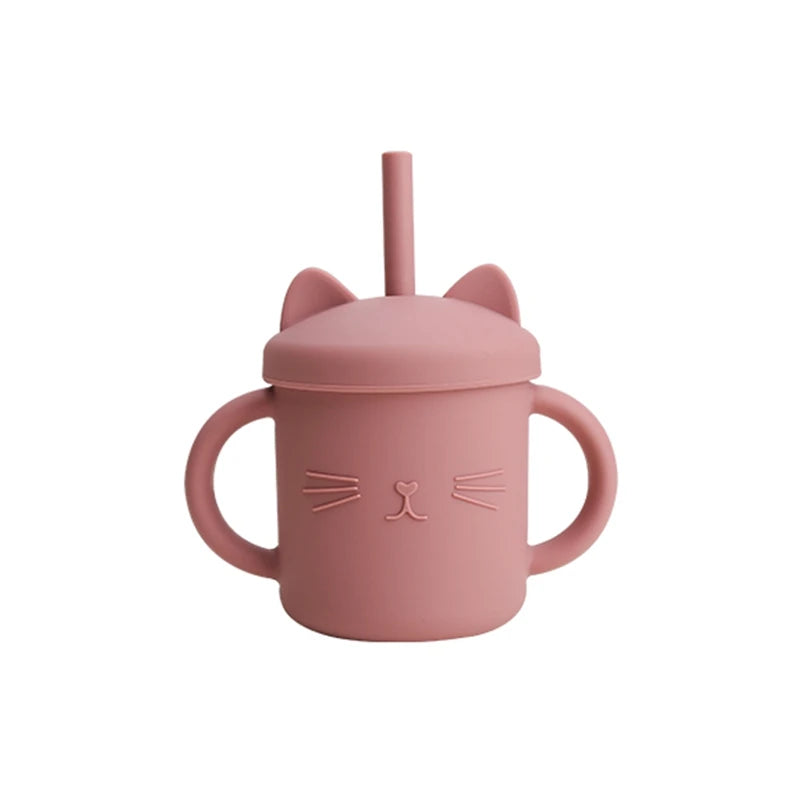 Pink sippy cup with cat ears and face design on a white background