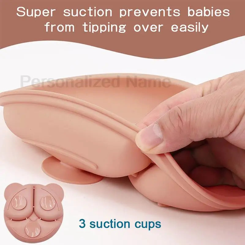 Pink silicone cup with suction cups held by a hand, labeled 'Super suction prevents babies from tipping over easily'.
