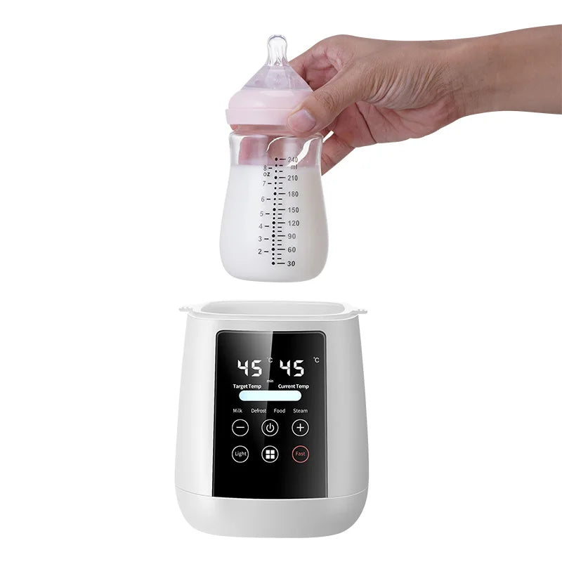 Hand holding a baby bottle above a digital bottle warmer with a white background