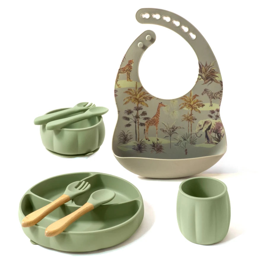 Children's dining set with bib, plate, cup, and utensils on a white background