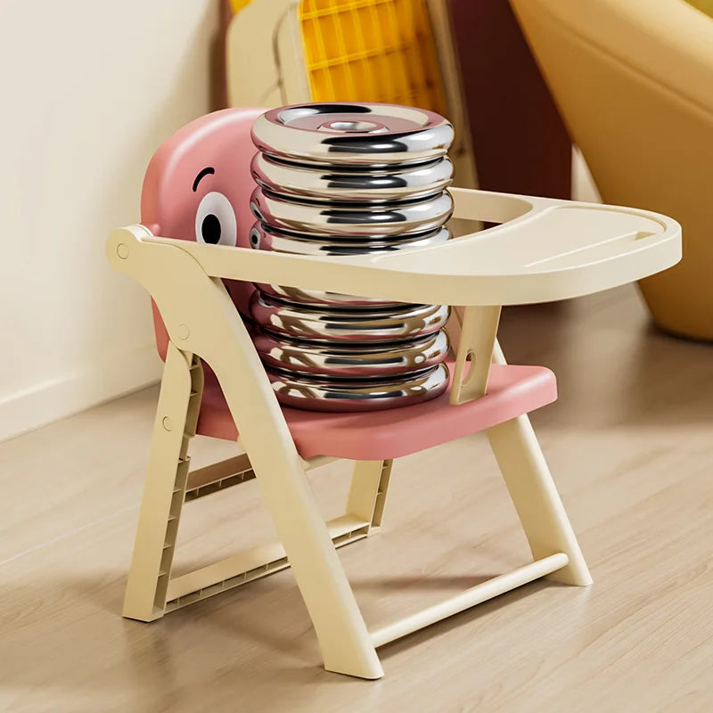 Children's high chair with pink seat and beige frame, featuring cartoon face design, on a light wooden floor.