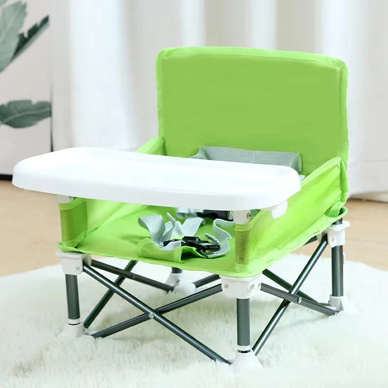 Green and white folding chair with tray on a light background