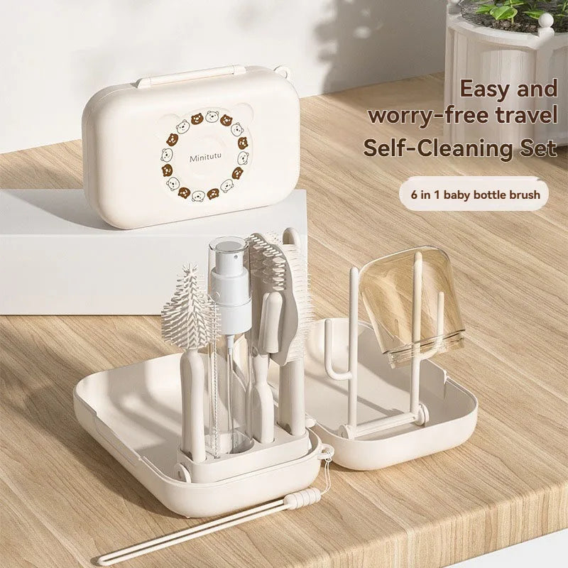 Baby bottle cleaning set with brush, bottle, and stand on a wooden surface