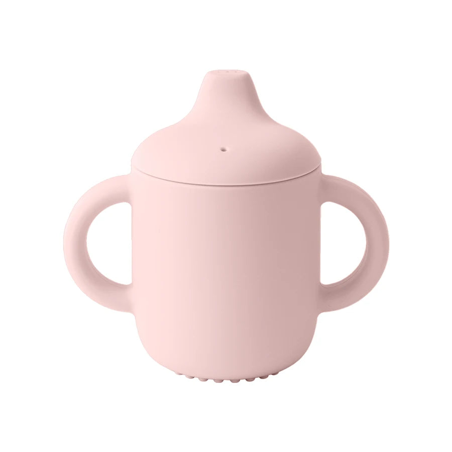Pink sippy cup with a lid on a white background