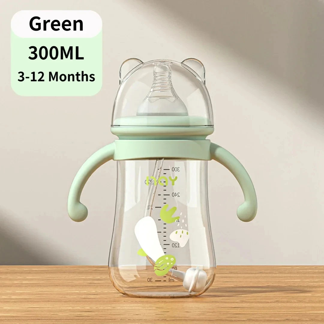 Green baby bottle with handles on a wooden surface