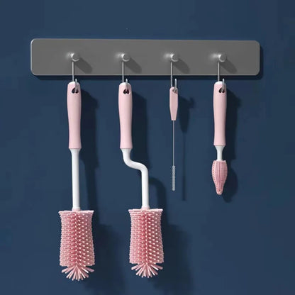 Set of four pink cleaning brushes hanging on a gray magnetic strip against a blue background
