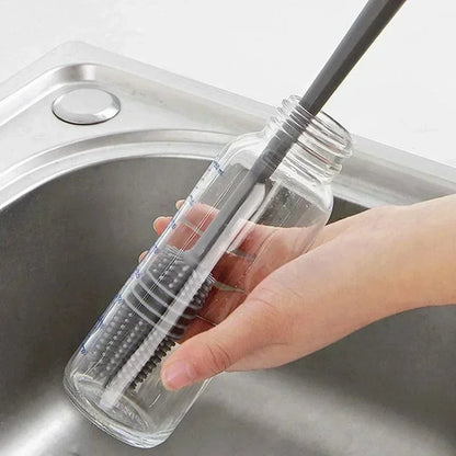 Clear bottle with a brush inside held over a sink