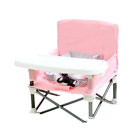 Pink folding chair with a white tray on a white background