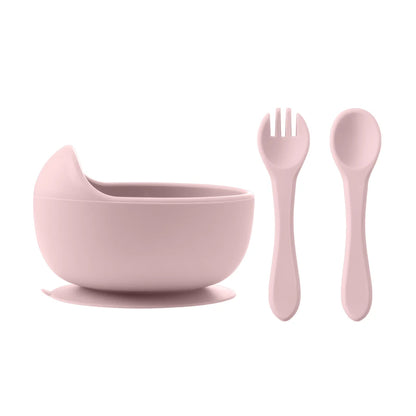 Pink children's bowl, spoon, and fork set on a white background