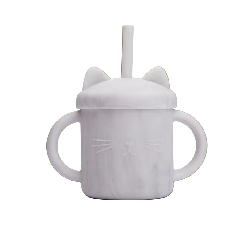 White sippy cup with cat ears and face design on a white background