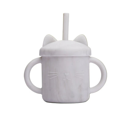 White sippy cup with cat ears and face design on a white background