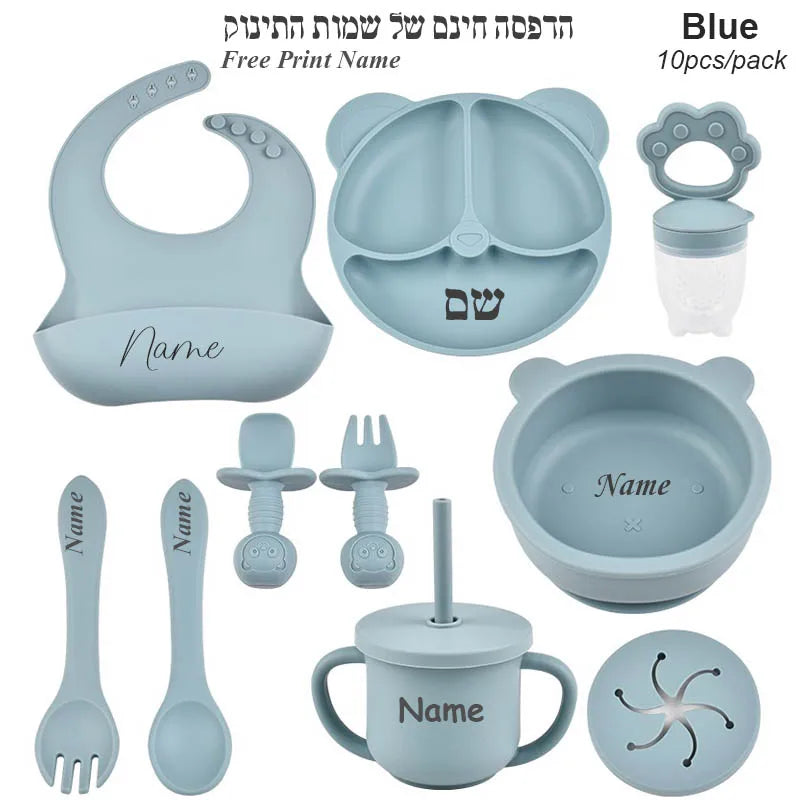Blue baby utensil set with various items including a bib, bowl, cup, and spoons on a white background.